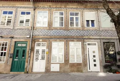 a building with green doors and windows on a street at PORTO CONCEPT HOME - Campo Alegre in Porto