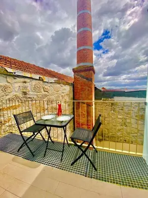 a patio with a table and a chair on a building at Padre António Vieira flat E - 2 Bedroom Near Campanhã train station in Porto
