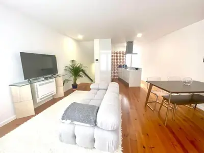 a living room with a white couch and a table at Padre António Vieira flat E - 2 Bedroom Near Campanhã train station in Porto