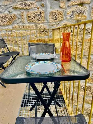 a glass table with a plate and a vase on a balcony at Padre António Vieira flat E - 2 Bedroom Near Campanhã train station in Porto