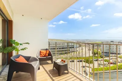 a balcony with chairs and a view of the city at Dragão - Indigo Antas Park in Porto