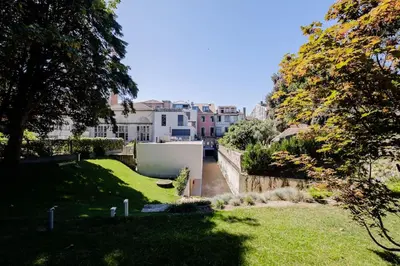 a yard with green grass and buildings in the background at Boutique Rentals-Primrose Terrace&Garage in Porto