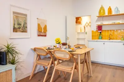 a kitchen and dining room with a wooden table and chairs at Campinho 1T - Stylish 1BR by LovelyStay in Porto