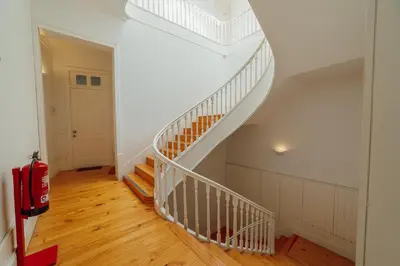 a white staircase in a home with a red suitcase at Downtown Excellence Apartment by Vacationy in Porto