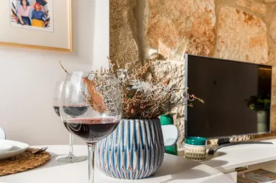 a glass of wine sitting next to a computer monitor at Fontainhas Elite Apartments in Porto