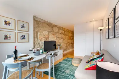 a living room with a couch and a table and a tv at Fontainhas Elite Apartments in Porto