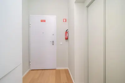 a white elevator in a room with a fire extinguisher at 31 de Janeiro Flat by Amber Star Rent in Porto