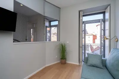 a living room with a blue couch and large windows at 31 de Janeiro Flat by Amber Star Rent in Porto