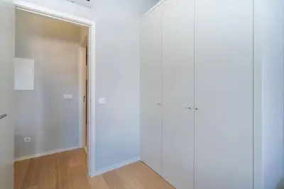 an empty hallway with white walls and wooden floors at 31 de Janeiro Flat by Amber Star Rent in Porto