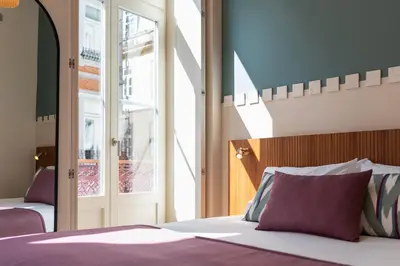 a bedroom with a bed with purple sheets and a window at Ando Living - Santa Catarina House in Porto