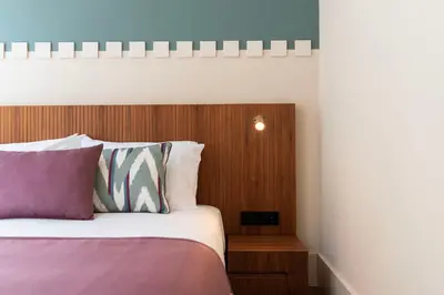 a bedroom with a bed with a wooden head board at Ando Living - Santa Catarina House in Porto