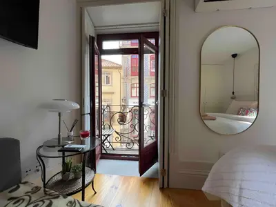a bedroom with a mirror and a bed and a balcony at Historic Porto Balcony Hideaway - Taipas House 60 in Porto