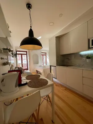 a kitchen and living room with a table and chairs at Historic Porto Balcony Hideaway - Taipas House 60 in Porto
