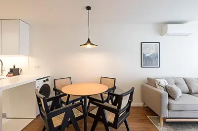 a kitchen and living room with a table and chairs at Santos Pousada 1071 by LovelyStay in Porto