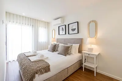 a white bedroom with a large bed and a window at Santos Pousada 1071 by LovelyStay in Porto